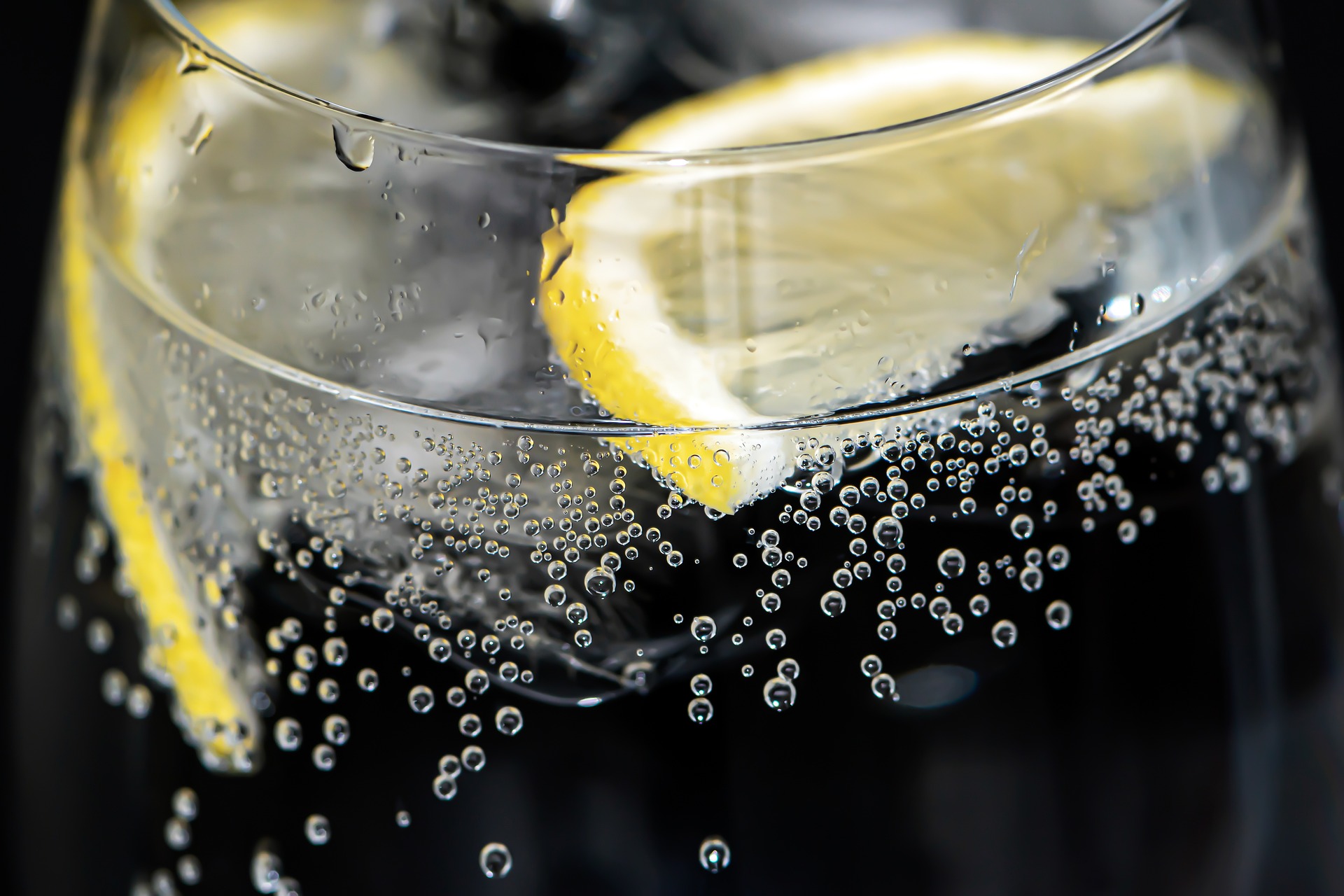 slices of lemon in water with bubbles