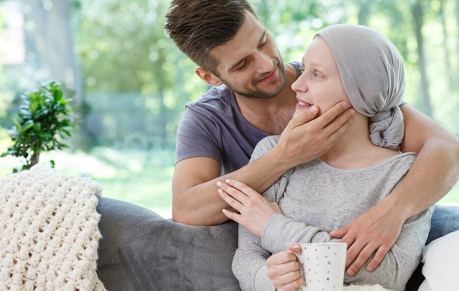 a man holding a woman who has gone through chemo