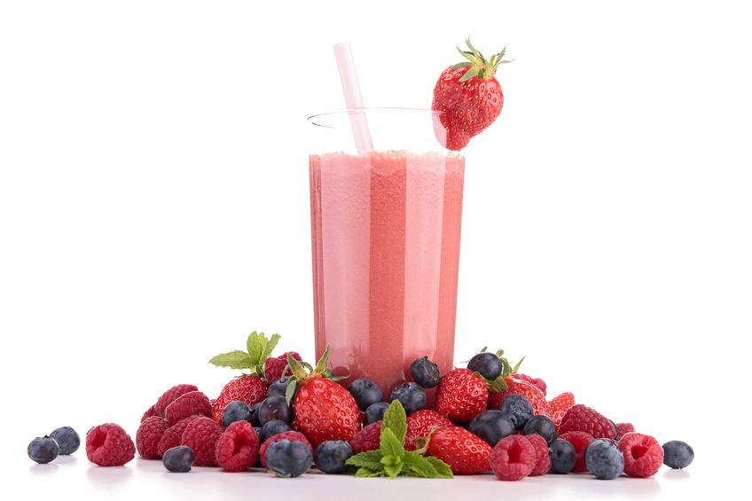 a fruit smoothie surrounded by berries