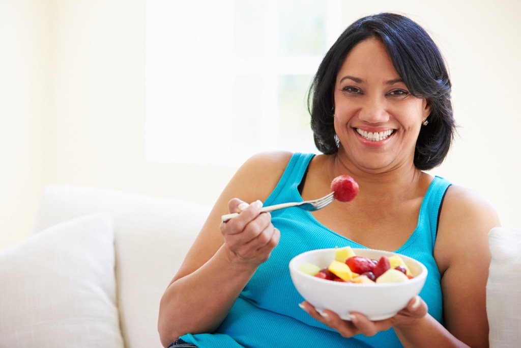 A woman eating a healthy fruit salad