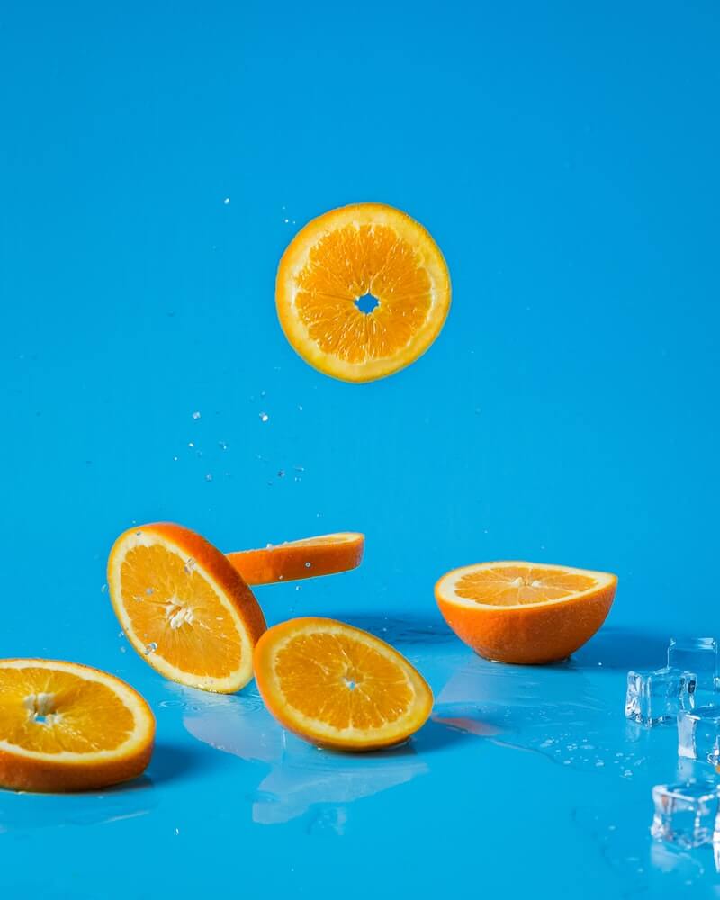 Sliced oranges falling into water