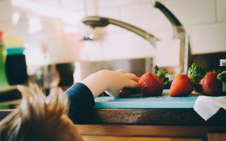 a child reaching for strawberries
