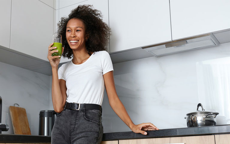 woman holding a green smoothie